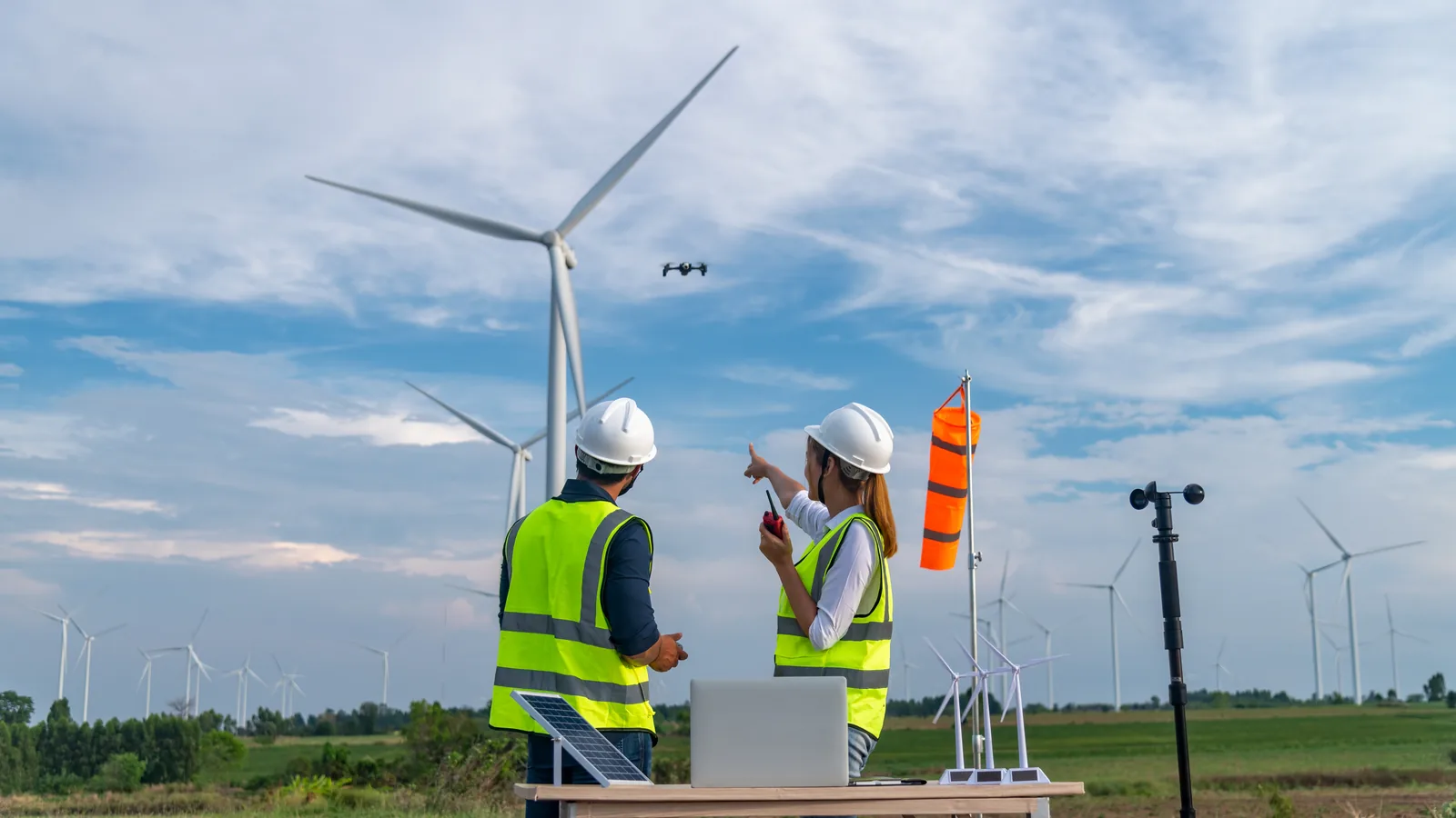 Commercial drone crew checking wind conditions during a wind-turbine inspection.