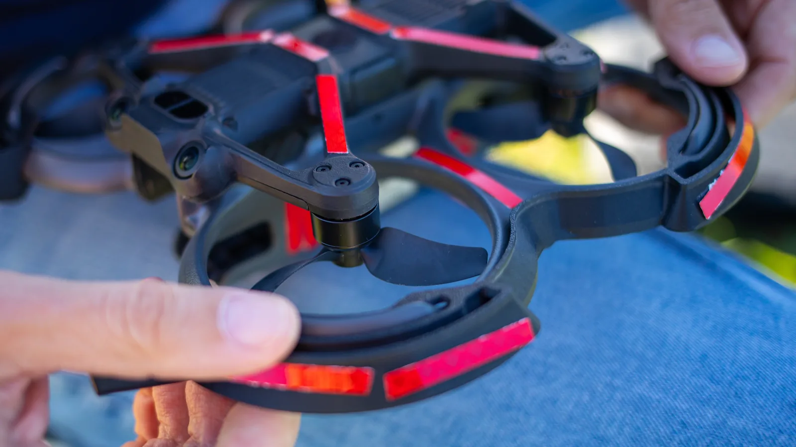 Pilot checking a propeller guard and motor before a drone flight.