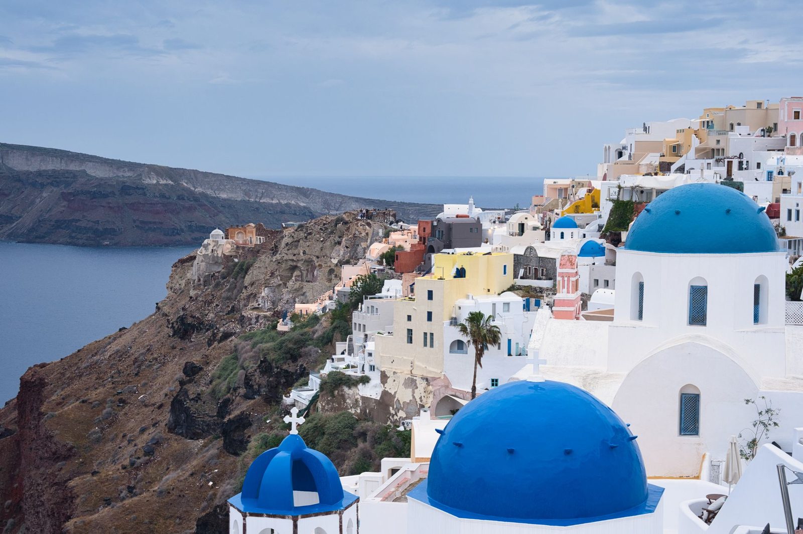 Whitewashed houses and blue-domed churches on the caldera rim at Oia, Santorini.