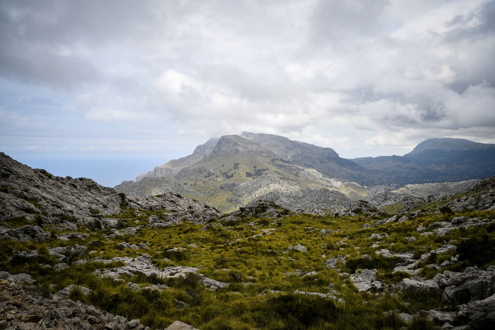 Rugged limestone ridges in Serra de Tramuntana, Mallorca, beneath a cloudy sky.