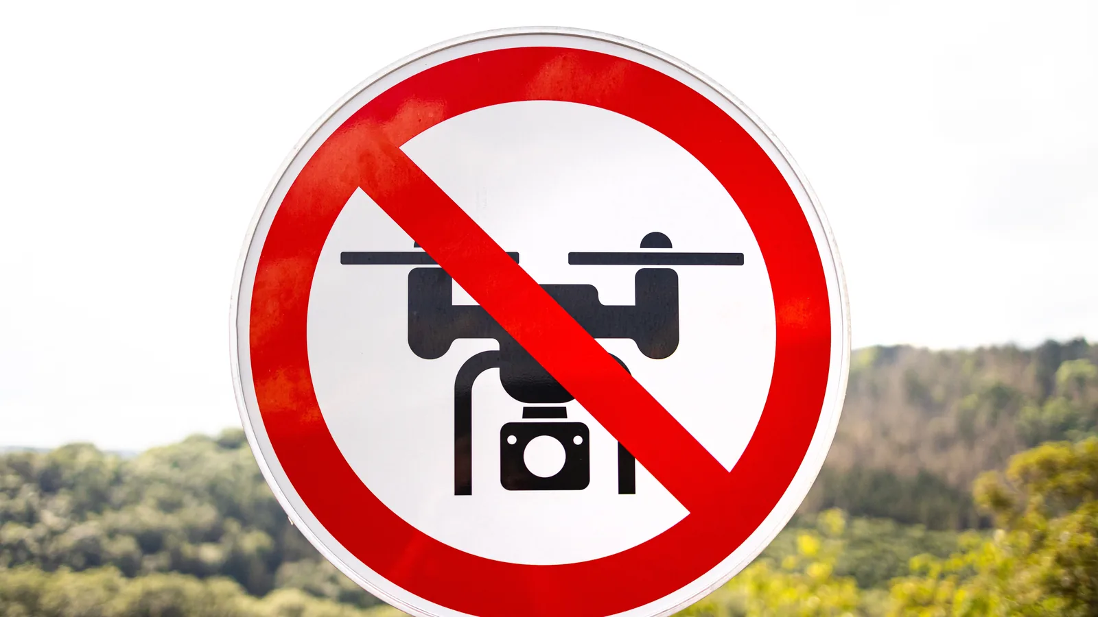 Red circular sign prohibiting drone flights in a restricted outdoor area
