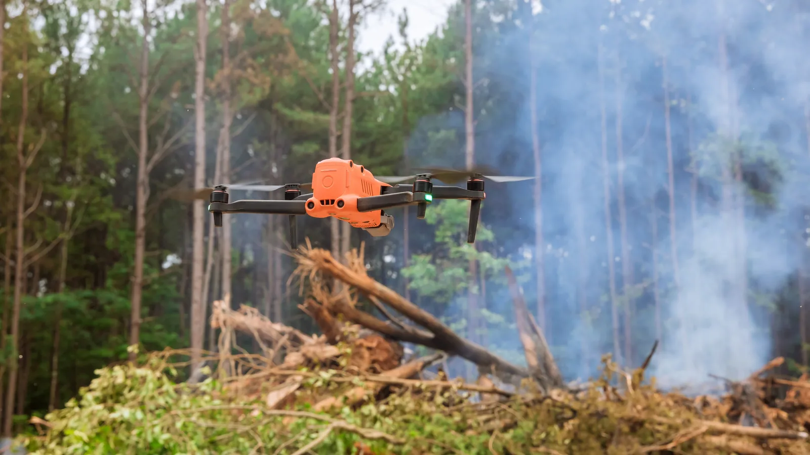 Drone flying above a smoky forest during an emergency response operation