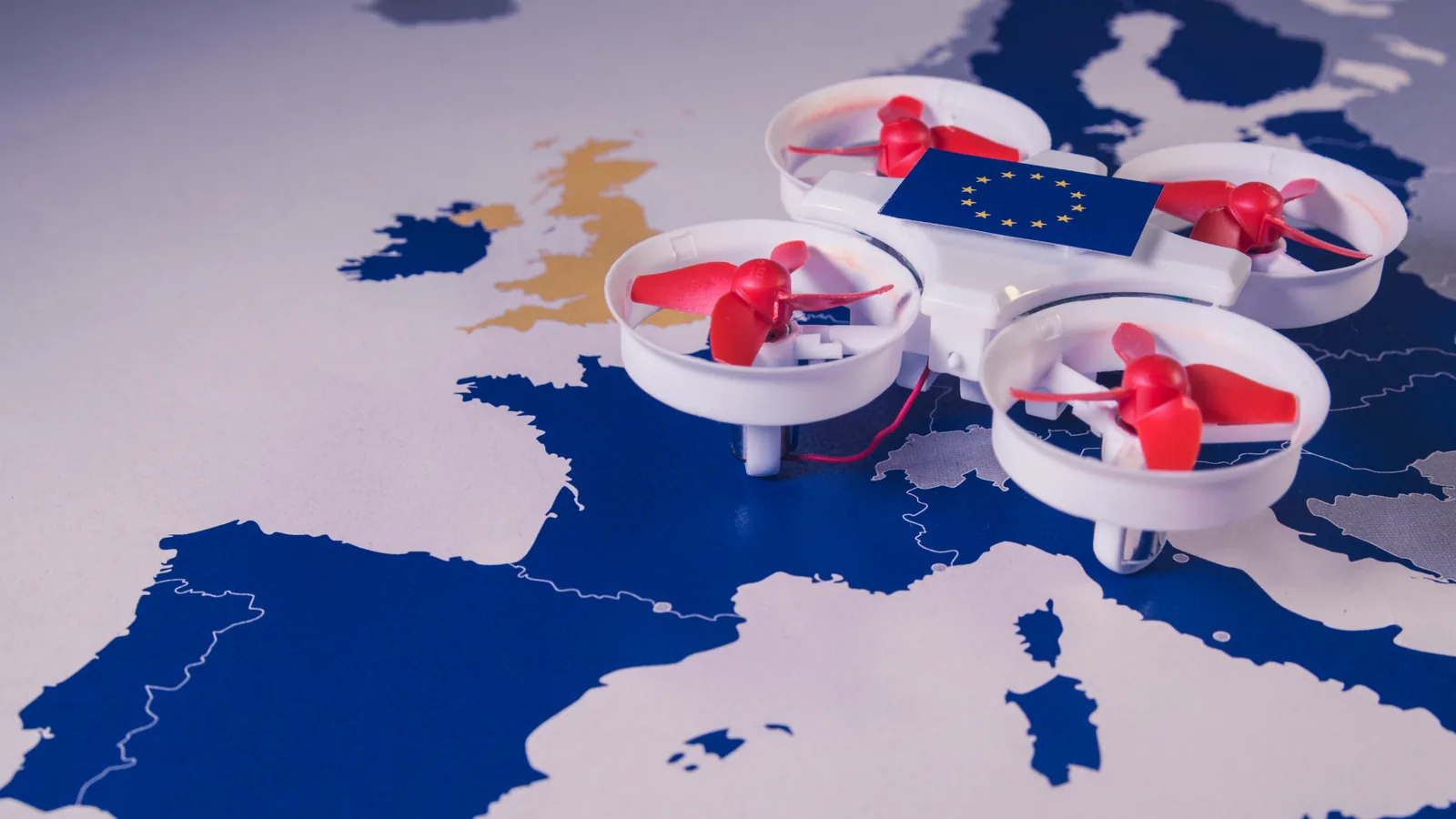 Small drone with an EU flag resting on a map of Europe
